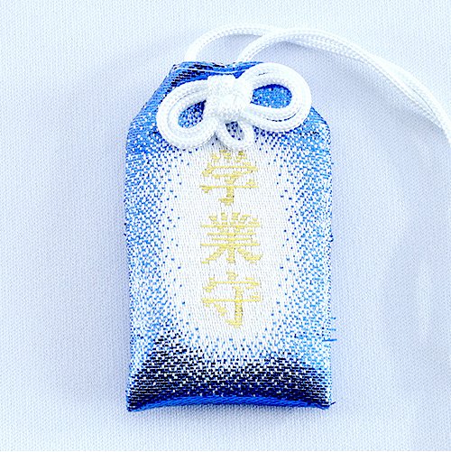 A white, rectangular omamori charm with a dark blue border. The kanji for "Gakugyo Mamori" are written in red in the center. A golden chrysanthemum emblem is at the top