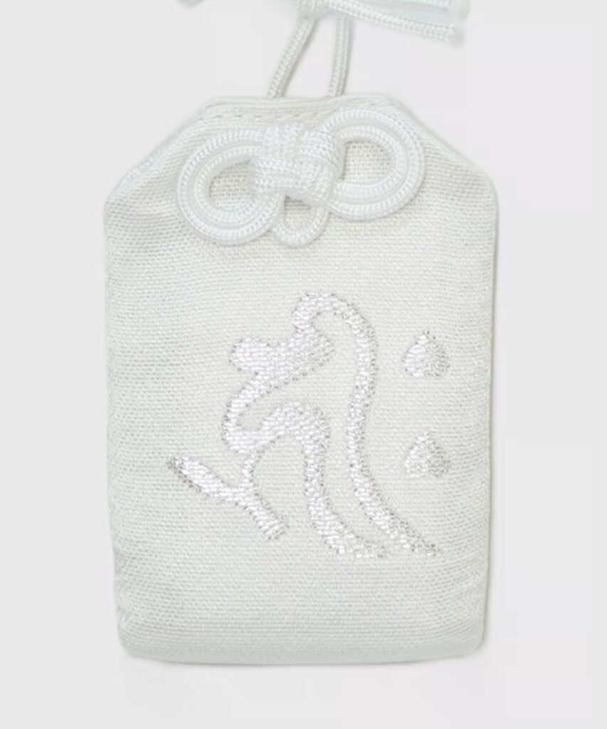 Solid white omamori pouch with the large, silver embroidered Japanese character "飛" (tobi or hi, meaning "fly" or "jump").