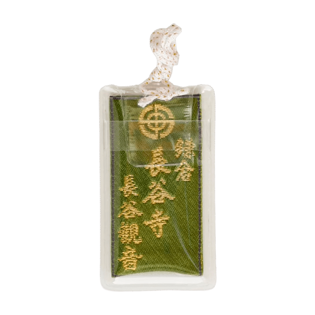 Green Japanese Omamori in a clear protective plastic sleeve with gold embroidered Kanji text and a white rope.